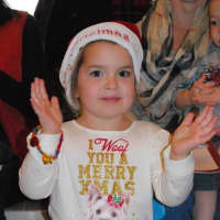 <p>A child claps her hands and gets in the holiday spirit. </p>