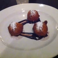 <p>Fried ricotta dough with fudge sauce and sour cherry sauce, one of the dessert options at Vespa.</p>
