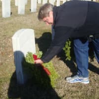 <p>David Bayne lays a wreath at the grave of a veteran during Darien&#x27;s ceremony.</p>