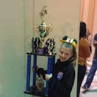 <p>Claudia Stuart of the 10-and-under Norwal Packers team stands with the trophy.</p>