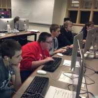 <p>Students focus intensely on coding.</p>