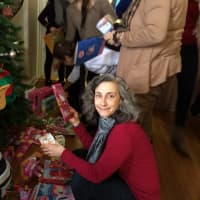 <p>Volunteer Gail Sider selects donated toys to give guests to bring home for children.</p>