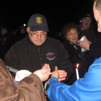 <p>Despite a stiff wind, more than 100 people managed to light candles for the vigil remembering slain police officers.</p>