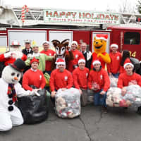 <p>Frosty the Snowman, Winnie the Pooh and other Santa&#x27;s helpers after arriving aboard a White Plains fire engine.</p>