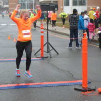 <p>A runner celebrates at the finish line in the 10k Boston Buildup race Sunday in Norwalk.</p>