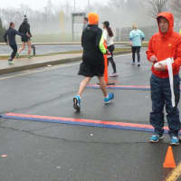 <p>Race organizer Jim Gerweck, at right, manning the finish line as runners pass by at the 10k Boston Buildup race Sunday in Norwalk.</p>
