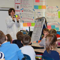 <p>High Touch High Tech scientist Justin Heriot teaches Holmes School first graders about the properties of gravity with tennis and ping pong balls.</p>