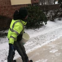 <p>A worker applies salt to the sidewalk on Mason Street during Tuesday&#x27;s snowfall.</p>