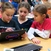 <p>Todd Elementary School fourth-grade students and first-graders play a Cool Math game on a personal device.</p>