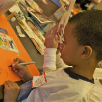 <p>Seven-year-old Marc Rowe works on his message in honor of MLK Day.</p>