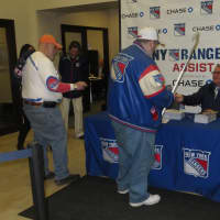 <p>Jay Meyer, center, of New Rochelle gets a signature from Ranger Glenn Anderson, right.</p>