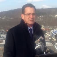 <p>Gov. Dannel Malloy keeps his hands in his pockets to keep warm as he talks about transportation problems in the state -- including those on I-84, behind him. </p>