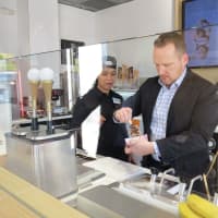 <p>Lead designer Tom Kowalski shows the proper technique to dipping an ice cream bar in Bronxville.</p>