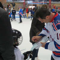 <p>Mike Hartman signing autographs for kids in Rye.</p>