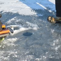 <p>An ice-fishing hole drilled through the ice on the Cross River Reservoir.</p>