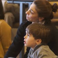 <p>Mom and son watch intently.</p>