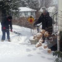 <p>Two neighbors team up to dig out a third neighbor on Wilson Street in Danbury on Tuesday. </p>