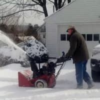 <p>A neighbor uses a snow blower to clear a large driveway on Tuesday afternoon. </p>