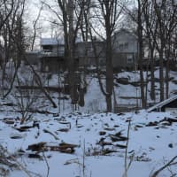 <p>Rubble is all that remains of a Mahopac Falls home damaged by a fire and subsequently demolished. The debris is mostly covered by snow.</p>