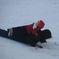 <p>Jose Andrade of White Plains coasts down a slope with his son, Fernando, aboard.</p>