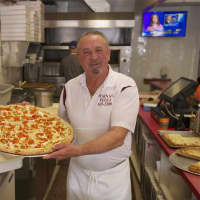 <p>Main Street Pizza Owner Joe Barbosa shows off one of his pies.</p>