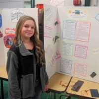 <p>A student presents a science project on electricity and sunlight.</p>