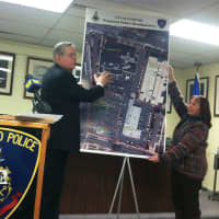 <p>Mayor David Martin points to a plan to move the current police headquarters onto the site of the current Hoyt Barnum House. Pam Coleman, historical society president, is helping to hold the enlarged photograph.</p>