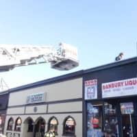 <p>Danbury firefighters douse a blaze at a Boost Mobile store at 20 White St. on Friday.</p>
