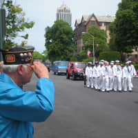 <p>John Condelario of New Rochelle salutes the uniformed men and women marching on North Avenue.</p>
