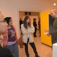 <p> David Opdyke speaks with students next to his artwork, Flores illicis (2012, cast urethane, pvc, paint, glass, 36 in x 8 in x 8 in).</p>