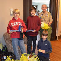 <p>From left, Troop 11 Boy Scouts Eric Meindle, Harry Nye and Jamie Meindle, as well as adult volunteer and Greenwich Scouting board member Tom Ohlson, collect food during last year&#x27;s drive.</p>