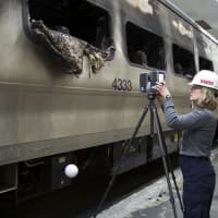 <p>National Transportation Safety Board investigator Kristin Poland sets up 3D Laser Scanner to create model of the damaged rail car. </p>