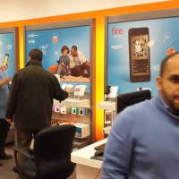 <p>Technician Joshua Rodriguez, left, helps an AT&amp;T customer as Oscar Cohn, tells the Daily Voice about its latest promotion.</p>