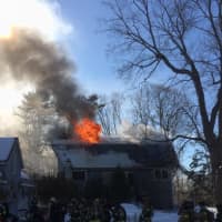 <p>Flames shoot from the roof of the three-story home at 266 Range Road in Wilton. </p>