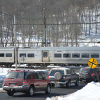 <p>A Metro-North train passes through a Chappaqua grade crossing. It has been cited for drawbacks that include proximity to a high school and interchange for a parkway.</p>