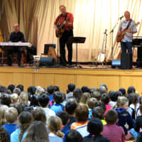 <p>Folk musician Tom Chapin, center, performed with his band at Todd Elementary School.</p>