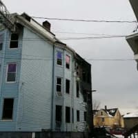 <p>Bridgeport firefighters douse the blaze at a three-story multifamily home on Wednesday afternoon.</p>