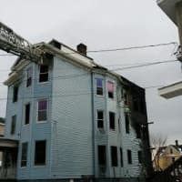 <p>Bridgeport firefighters douse the blaze at a three-story multifamily home on Wednesday afternoon.</p>