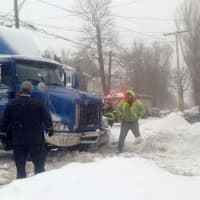 <p>The truck clears the snowbank and sidewalk as it is slowly pulled uphill. </p>