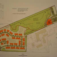 <p>A photo of the developer&#x27;s site plan for Somers Crossing. The townhouses are represented in the bottom cluster while the grocery store is represented in the upper right of the plan.</p>