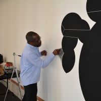 <p>Artist Osi Audu setting up his installation at Crossing Borders exhibit.</p>