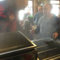 <p>Allan Klumac shows visitors how the sap is boiled to make pure maple syrup.</p>