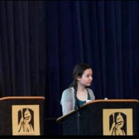 <p>Students at the podium during the symposium.</p>