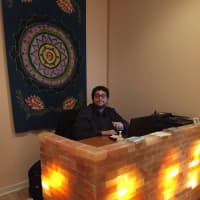 <p>Andrew Graciani, manager, Breathe Easy sits at his desk made of salt.</p>