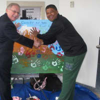 <p>From left, Westchester County Chief of Staff George Oros and St. Christophers, Inc. Kurt Kannemeyer make painted hand marks on the art canvas during the pep rally to support Kannemeyers upcoming Mount Kilimanjaro climb in Tanzan.</p>