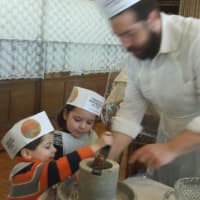 <p>Rabbi Hurwitz is showing twins Emily and Henry how to make thier very own matzoh. </p>