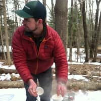 <p>Steve Conaway passes out cups of sap that have been boiled. The sap tastes like sugar water and has to be boiled longer in order to become maple syrup.</p>