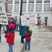 <p>Children hold signs in front of Town Hall as they await Team 26&#x27;s arrival.</p>