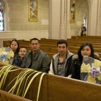 <p>A family sits in St. Mary&#x27;s with palms after Palm Sunday service.</p>