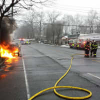 <p>Greenwich Firefighters stretch a hose to douse the flames. </p>